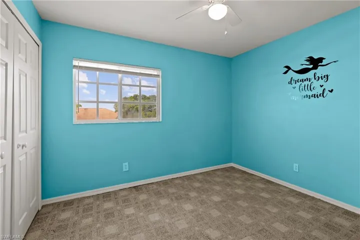 Unfurnished bedroom featuring carpet, a closet, and ceiling fan