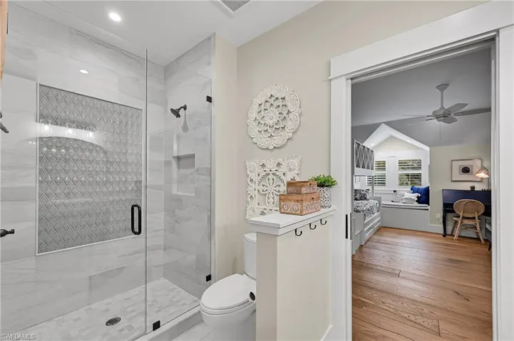 Glass enclosed walk-in shower with custom tile work and modern fixtures