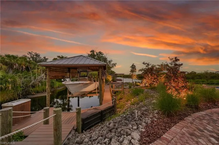 Private composite dock featuring a covered boat lift with room for 28 ft boat, fish cleaning station, and direct access to Deep Creek- perfect for boating and waterfront living