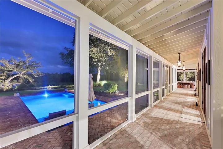 Expansive screened in outdoor living space spanning the entire back of the home, allowing all the french doors to remain open, creating seamless indoor-outdoor living.