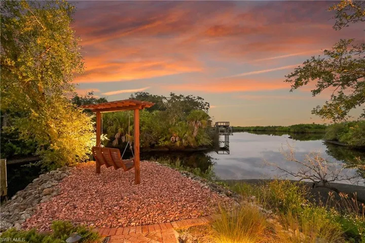 Peaceful waterfront retreat with pergola porch swing, perfectly positioned to enjoy stunning water views
