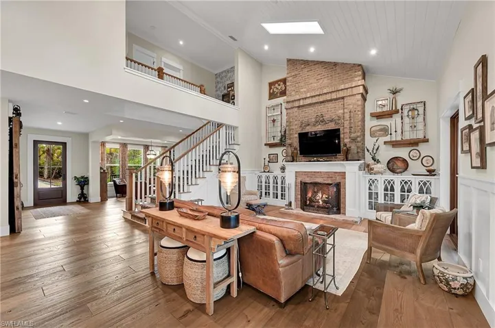 Light filled great room with vaulted ceilings, rich hardwood floors and expansive doors that bring the outdoors in