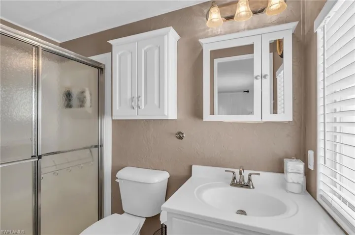 Bathroom with vanity, a walk-in shower, and LVP floors