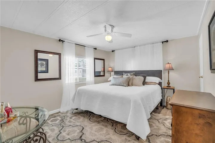 Bedroom featuring an ensuite bath, LVP floors, walk-in closet and ceiling fan
