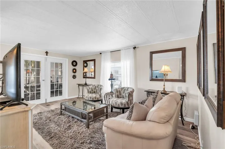 Living room featuring french doors to the screened lanai, a textured ceiling, and LVP floors