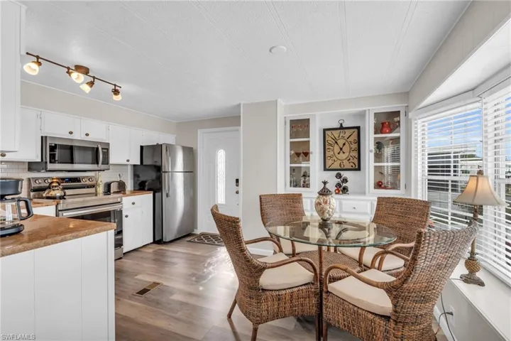 Dining room featuring a textured ceiling, LVP floors, bay window, and built-ins