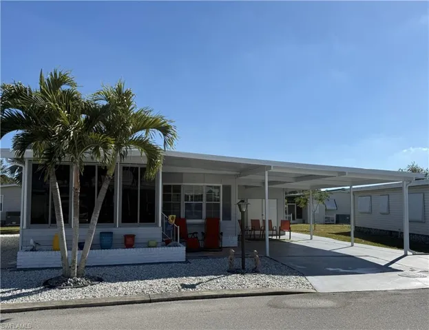 View of front of house featuring an attached carport and driveway