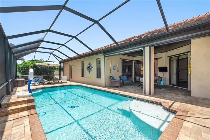 Swimming pool with a patio area and glass enclosure