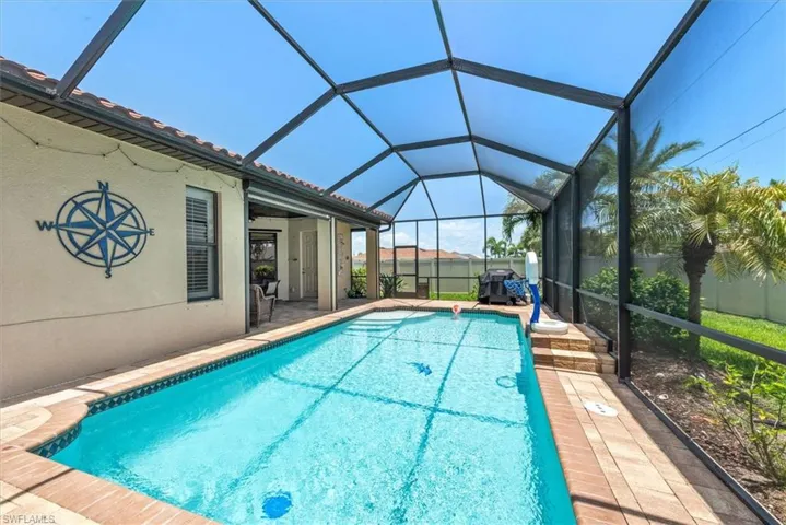 Swimming pool featuring a patio area and glass enclosure