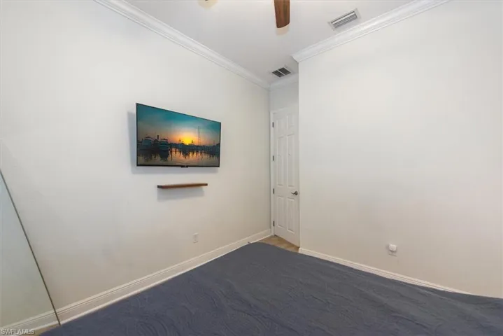 Empty room with crown molding, ceiling fan, and baseboards