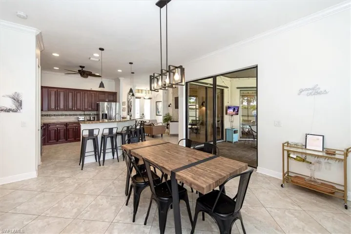 Dining space with a ceiling fan, crown molding, light tile patterned flooring, recessed lighting, and baseboards