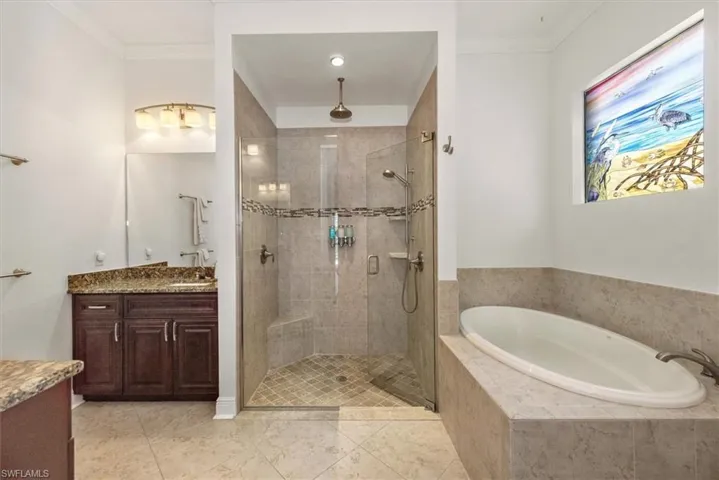Full bathroom with vanity, a shower stall, a bath, ornamental molding, and tile patterned flooring