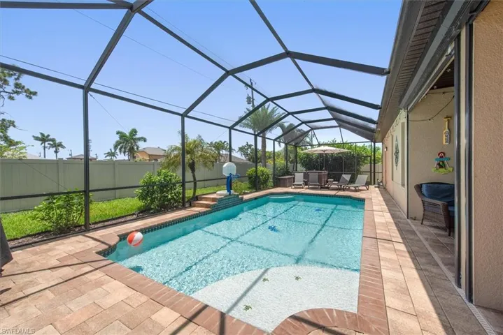 View of pool featuring a patio area, a fenced backyard, and a lanai