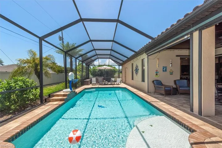 View of pool featuring a patio area and glass enclosure
