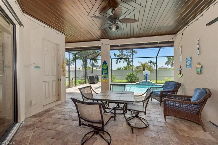 Sunroom / solarium with ceiling fan and a water view