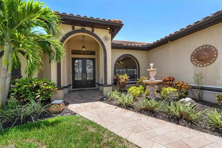 Property entrance featuring french doors, a tile roof, and stucco siding