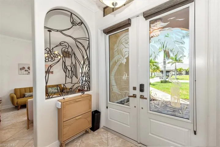 Entryway featuring ornamental molding, baseboards, french doors, and light marble finish floors