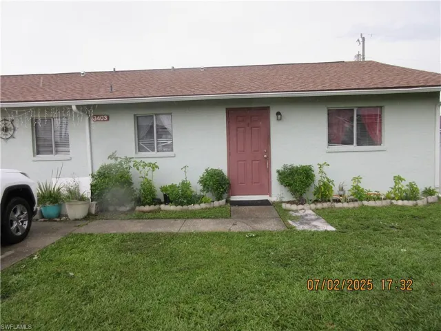 Ranch-style home with a front lawn, stucco siding, and roof with shingles
