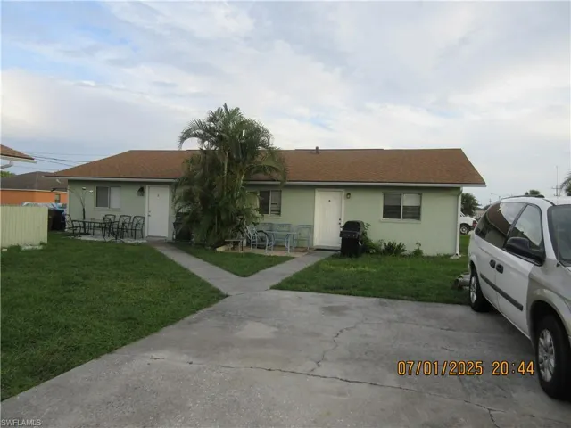 View of front facade featuring a front yard and stucco siding
