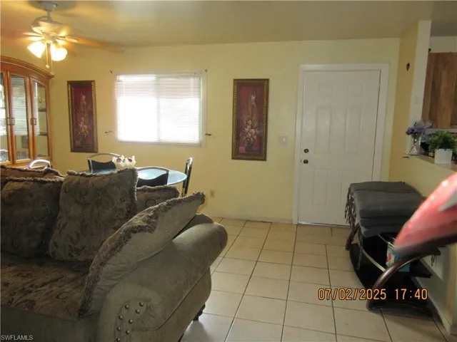 Living area with a ceiling fan and light tile patterned floors