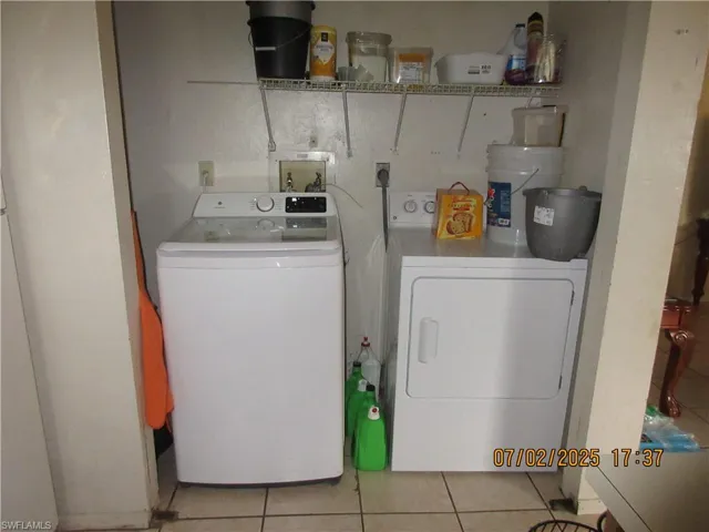washer and dryer closet off the kitchen and light tile patterned floors