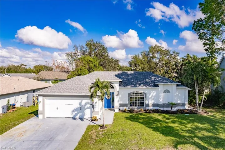 Ranch-style house featuring a front lawn and a garage
