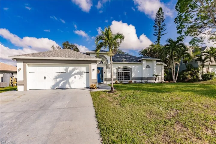Single story home with a garage and a front lawn