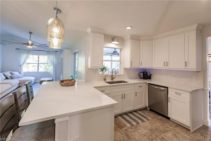 Kitchen featuring hanging light fixtures, kitchen peninsula, sink, and stainless steel dishwasher