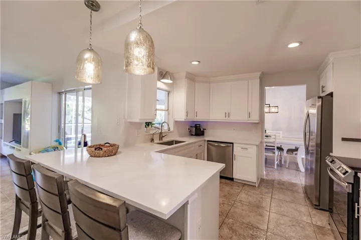 Kitchen with white cabinets, appliances with stainless steel finishes, a healthy amount of sunlight, and sink
