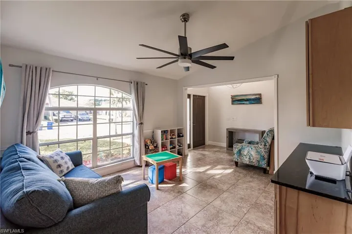 Tiled Den featuring ceiling fan and lofted ceiling