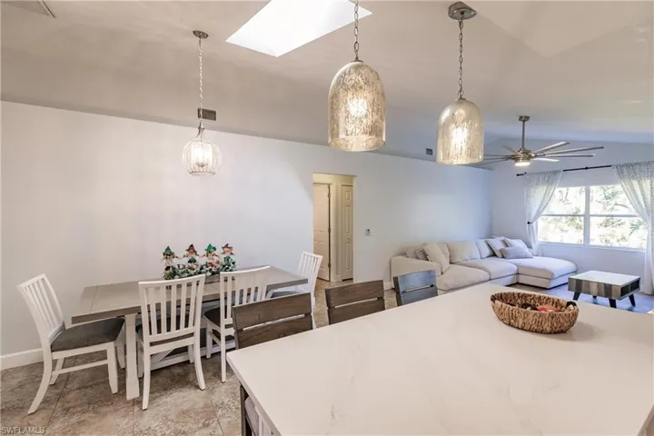 Dining space featuring lofted ceiling with skylight and ceiling fan