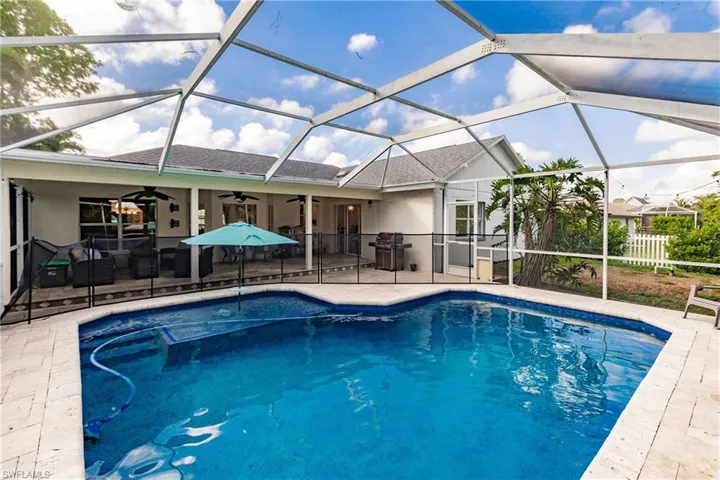 View of swimming pool featuring screen enclosure, ceiling fan, and a patio area