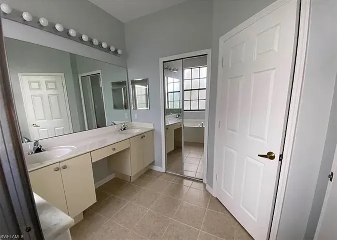 Bathroom featuring double vanity and tile patterned flooring