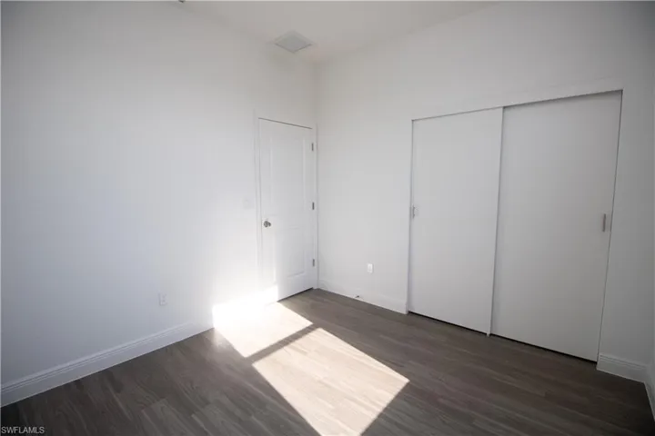 Bedroom featuring a closet and dark vinyl-style flooring