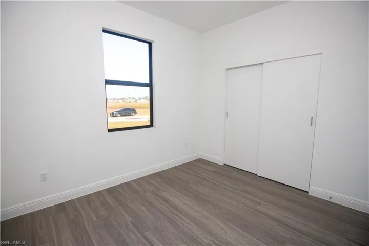Bedroom featuring a closet and dark vinyl-style flooring