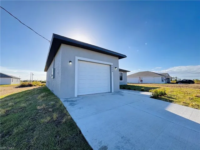 Garage featuring a lawn