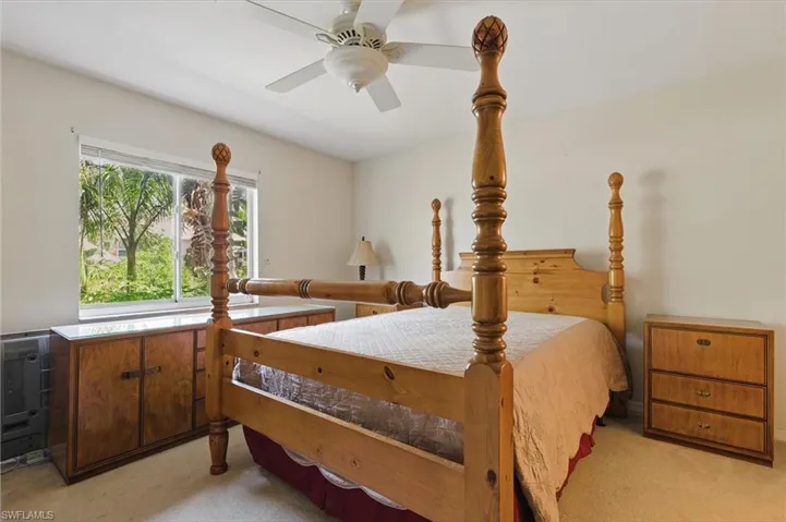 Bedroom featuring heating unit, a ceiling fan, and light colored carpet