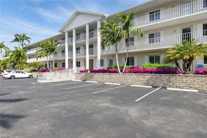 View of building exterior featuring uncovered parking