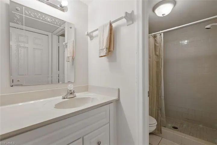 Full bathroom featuring tile patterned floors, vanity, a shower stall, and toilet