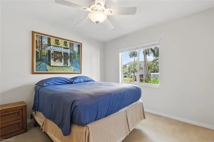Bedroom with ceiling fan, carpet floors, and baseboards