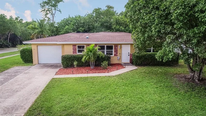 Ranch-style home with a garage and a front lawn