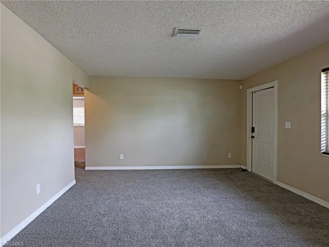 Carpeted spare room with a textured ceiling
