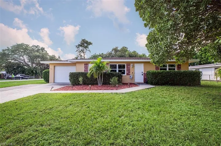 Ranch-style home with a front yard and a garage