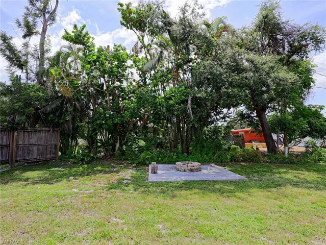 View of yard with an outdoor fire pit and a patio area