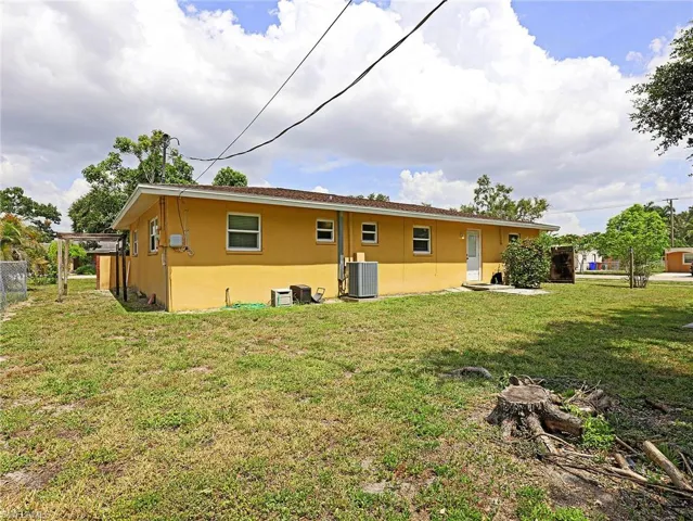 Rear view of house with a yard and cooling unit