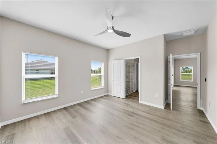 Unfurnished bedroom with light hardwood / wood-style floors, a walk in closet, and ceiling fan