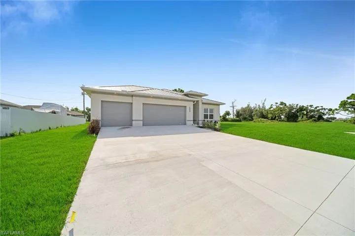 View of front of property with a garage and a front lawn