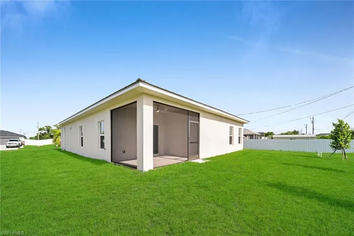 Rear view of property with a yard