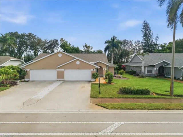 Single story home with a front lawn, stucco siding, driveway, and an attached garage