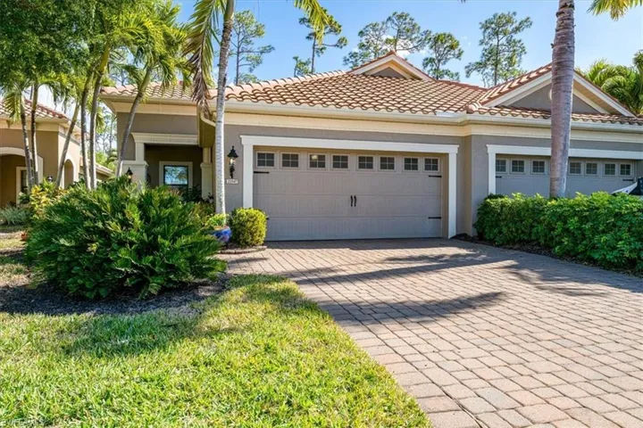 View of front of property featuring driveway, stucco siding, a tiled roof, and an attached garage